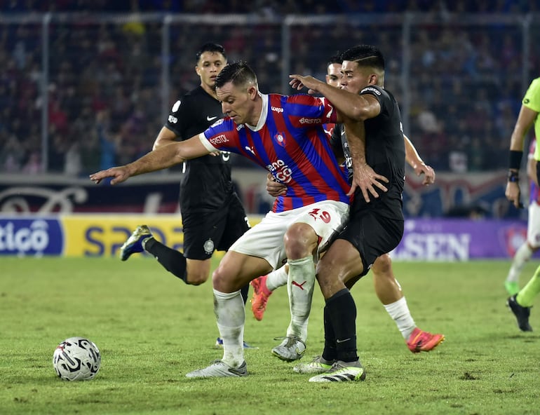 Diego Churín (i), jugador de Cerro Porteño, domina el balón frente a Hugo Benítez, futbolista de Olimpia, en el partido por la fecha 17 del torneo Apertura 2024 del fútbol paraguayo en el estadio La Nueva Olla, en Asunción.