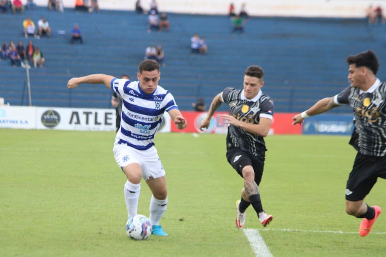 Elías Alfonso se lleva el balón ante la marca de Merlini y Espinoza