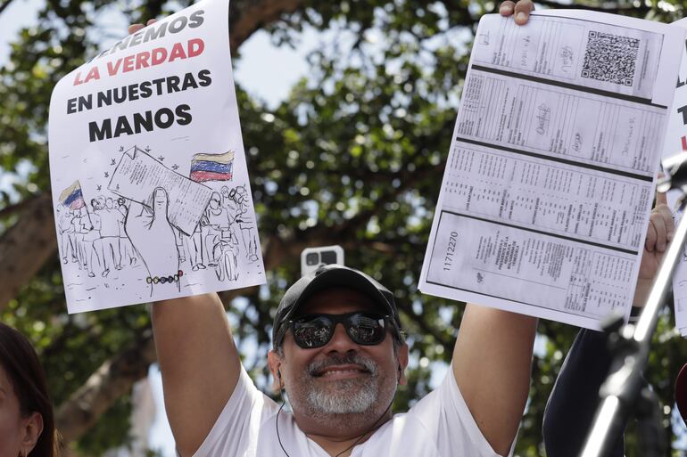 Un ciudadano venezolano sostiene un cartel en una concentración para manifestarse en contra de los resultados oficiales de las elecciones en Venezuela. La coalición opositora mayoritaria de Venezuela, la Plataforma Unitaria Democrática (PUD), denunció este sábado que funcionarios de la Guardia Nacional Bolivariana (GNB, policía militarizada) reprimieron a ciudadanos que salieron a la concentración convocada por el antichavismo en Maracay, estado Aragua.