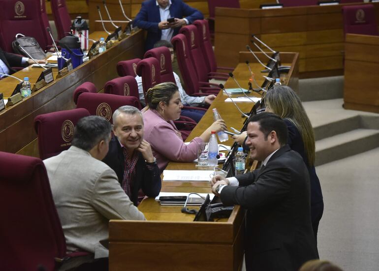 Los diputados Esteban Samaniego (de espaldas), Daniel Centurión y Alejandro Aguilera conversan durante la sesión desarrollada en la fecha.