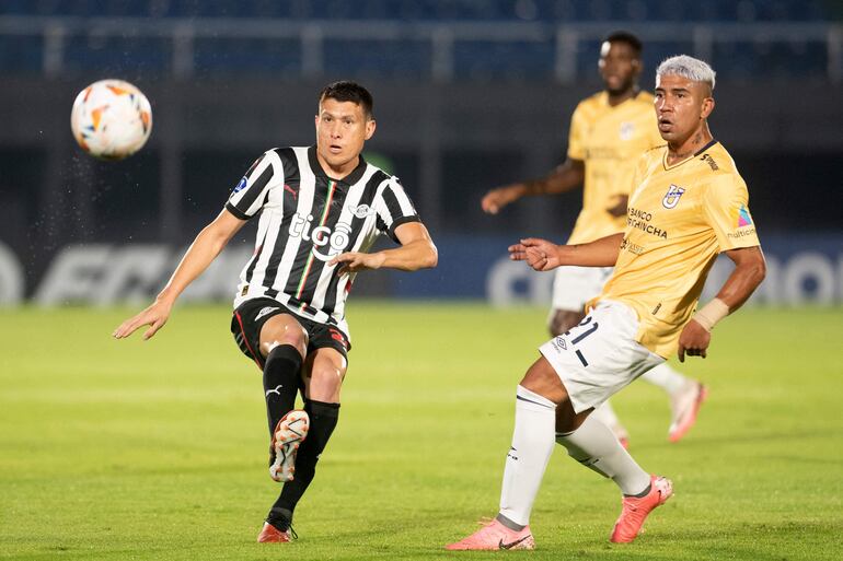 El volante de Libertad, Hernesto Caballero, no le saca la vista al balón ante la llegada del jugador ecuatoriano Luciano Nieto.