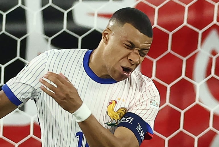 TOPSHOT - France's forward #10 Kylian Mbappe reacts after being injured during the UEFA Euro 2024 Group D football match between Austria and France at the Duesseldorf Arena in Duesseldorf on June 17, 2024. (Photo by FRANCK FIFE / AFP)