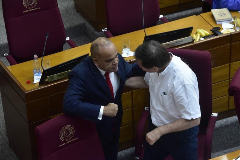 El senador Basilio "Bachi" Núñez (ANR, HC) conversa con el senador Orlando Penner (PPQ, aliado cartista) en la sala de sesiones del Senado.