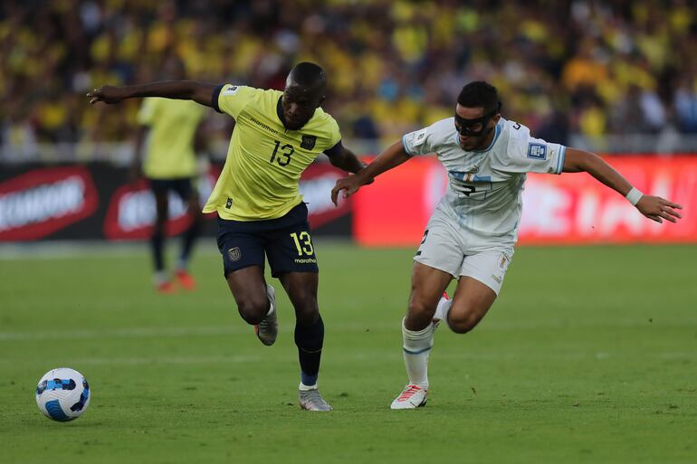 El delantero Enner Valencia, jugador de Ecuador, disputa el balón con Sebastián Cáceres, futbolista de Uruguay, en un partido de las Eliminatorias Sudamericanas para el Mundial 2026 en el estadio Rodrigo Paz Delgado en Quito, Ecuador.
