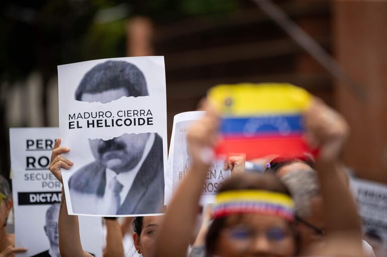 Un hombre sostiene un cartel con la imagen del presidente de Venezuela, Nicolás Maduro, durante una protesta liberta de familiares de presos políticos en Venezuela exigiendo su libertad el pasado miércoles, en Caracas.