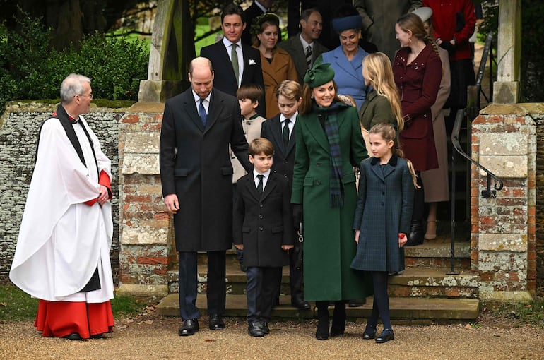 Los príncipes de Gales y sus hijos junto al reverendo Paul Williams después de asistir al tradicional servicio del día de Navidad de la Familia Real en la Iglesia de Santa María Magdalena en Sandringham, Norfolk.
(Oli SCARFF / AFP)