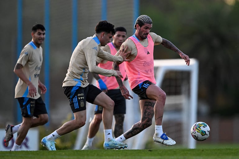 Rodrigo De Paul (d), jugador de la selección de Argentina, en el entrenamiento previo al partido contra Paraguay por la fecha 11 de las Eliminatorias Sudamericanas 2026 en el Predio Lionel Andrés Messi, en Ezeiza, Argentina.