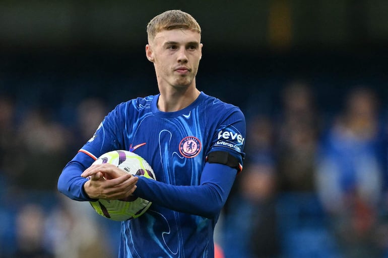 Chelsea's English midfielder #20 Cole Palmer walks off with the match ball having score all four goals in the English Premier League football match between Chelsea and Brighton and Hove Albion at Stamford Bridge in London on September 28, 2024. Chelsea won the game 4-2. (Photo by Glyn KIRK / AFP) / RESTRICTED TO EDITORIAL USE. No use with unauthorized audio, video, data, fixture lists, club/league logos or 'live' services. Online in-match use limited to 120 images. An additional 40 images may be used in extra time. No video emulation. Social media in-match use limited to 120 images. An additional 40 images may be used in extra time. No use in betting publications, games or single club/league/player publications. / 