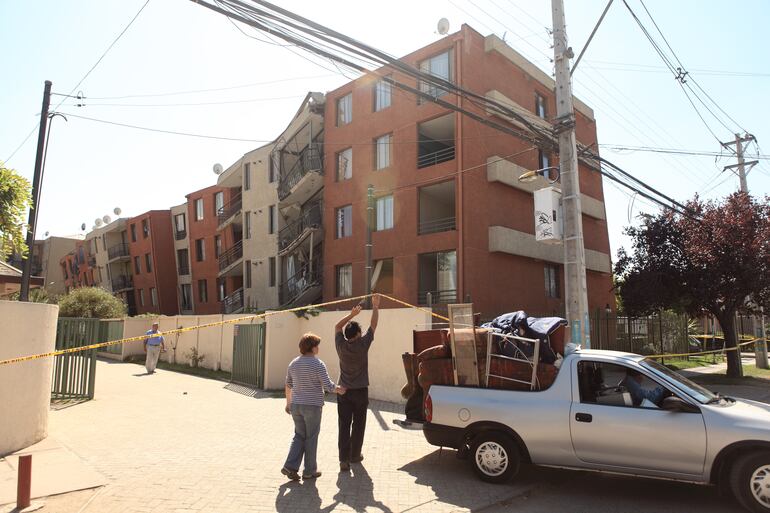 Familia mudándose de su edificio de apartamentos con daños estructurales durante el terremoto de 8,8 del 27 de febrero de 2010 en Chile.