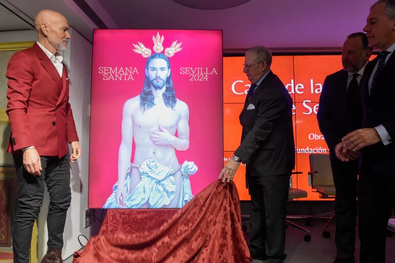 El artista español Salustiano Garcia junto a la pintura creada para la "Semana Santa de Sevilla 2024",  durante la presentación de la obra. 