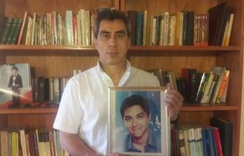 El exdiputado Luis Villamayor sostiene una fotografía de su hijo fallecido, Alex.