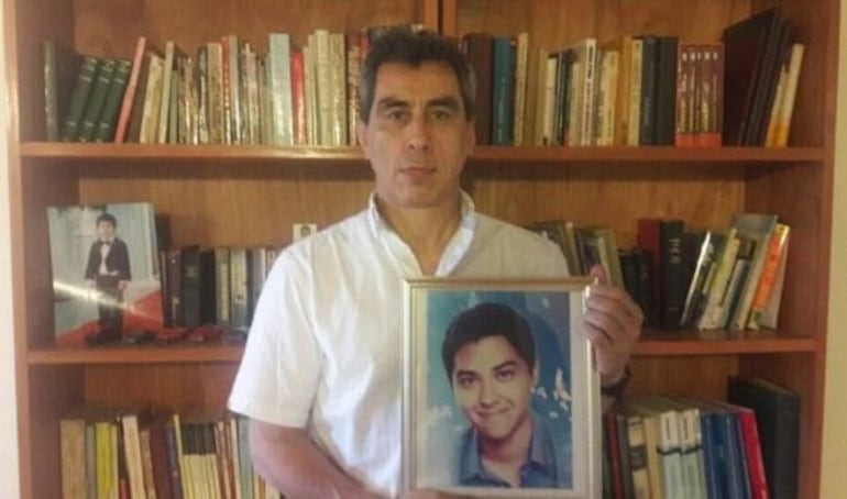 El exdiputado Luis Villamayor sostiene una fotografía de su hijo fallecido, Alex.