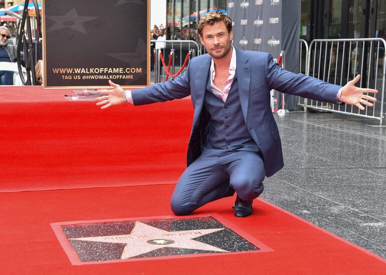 El actor australianoi Chris Hemsworth posa feliz con su estrella en el Paseo de la Fama de Hollywood, California.