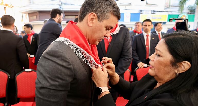 Santiago Peña, poniéndose el pañuelo colorado al cuello, como aquel 29 de octubre de 2016, cuando pasó de ser liberal a afiliarse a la ANR para seguir en su cargo de ministro de Hacienda.