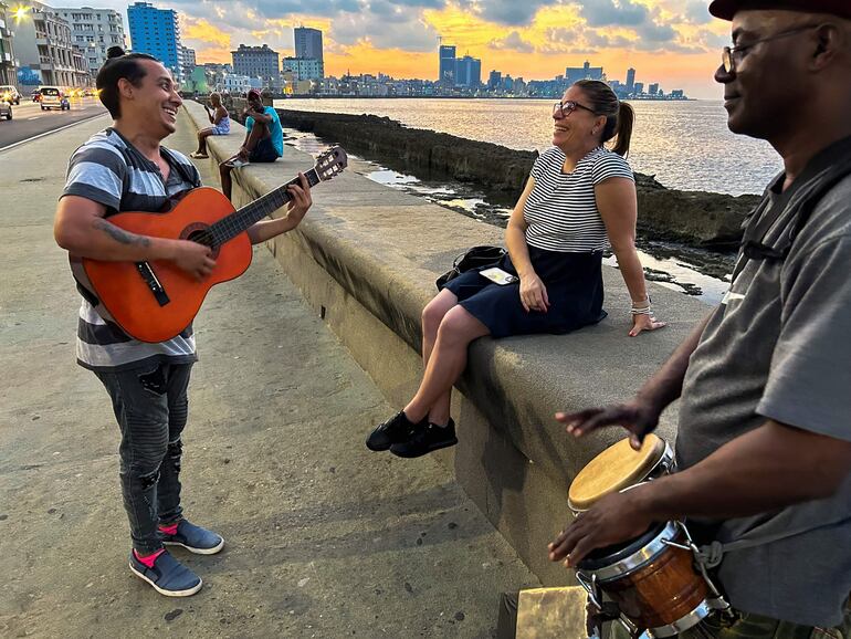 Artistas cubanos cantan boleros en el malecón de La Habana.