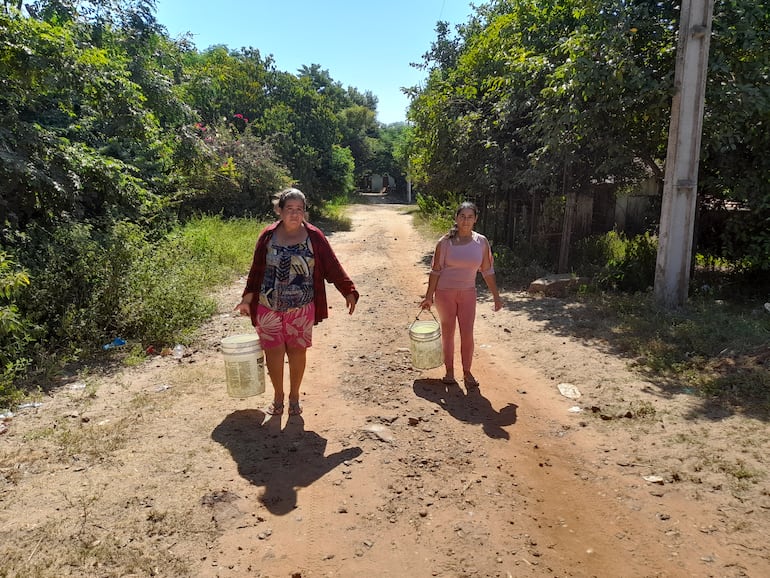 Pobladoras del asentamiento Atinguy caminan cerca de dos kilómetros para conseguir un poco agua del pozo de un vecino.