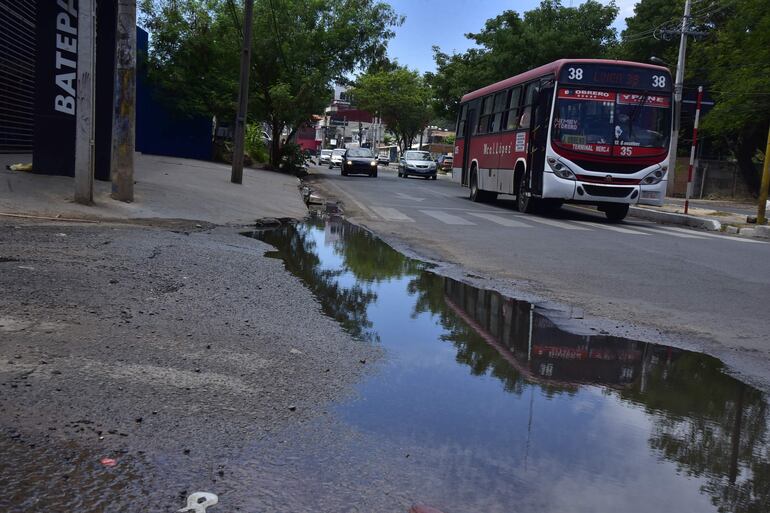 En Asunción, peatones transitan por calles y veredas inundadas de agua, a causa de los caños rotos de la Essap. 