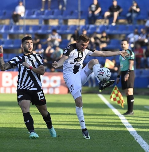 Héctor Villalba, de Libertad, pelea el balón con Walter Clar, jugador de Tacuary.