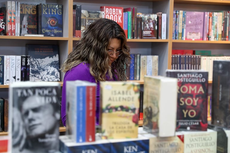 Una persona observa libros es un stand de la Feria Internacional del Libro de Quito. Los libros y las películas del futuro podrían empezar a parecerse entre sí si las industrias creativas se entregan a la inteligencia artificial (IA) para ayudarse a escribir historias, advirtió un estudio publicado el viernes.