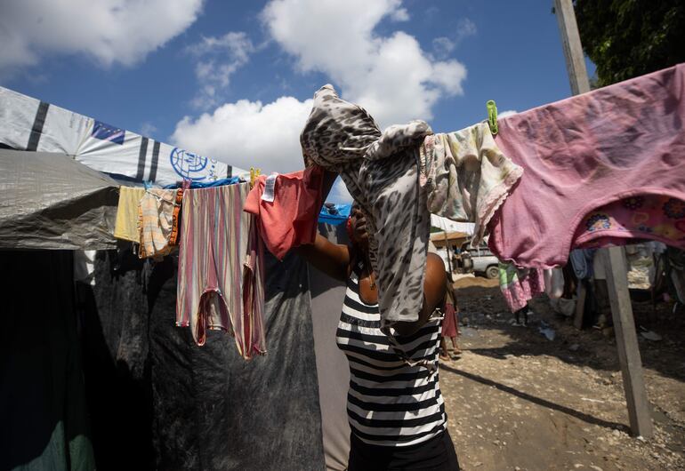 Una mujer cuelga ropa en el campamento de refugiados Carrade, este sábado en Puerto Príncipe (Haití). Unas 3.000 personas que tuvieron que huir de sus casas por la violencia conviven en un campamento de refugiados no lejos de la embajada de Estados Unidos en Puerto Príncipe. 