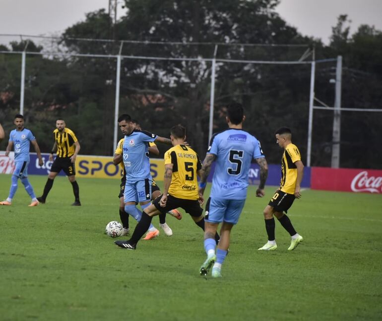 Jorge Colmán, de Resistencia, disputa el balón con los jugadores de Guaraní.