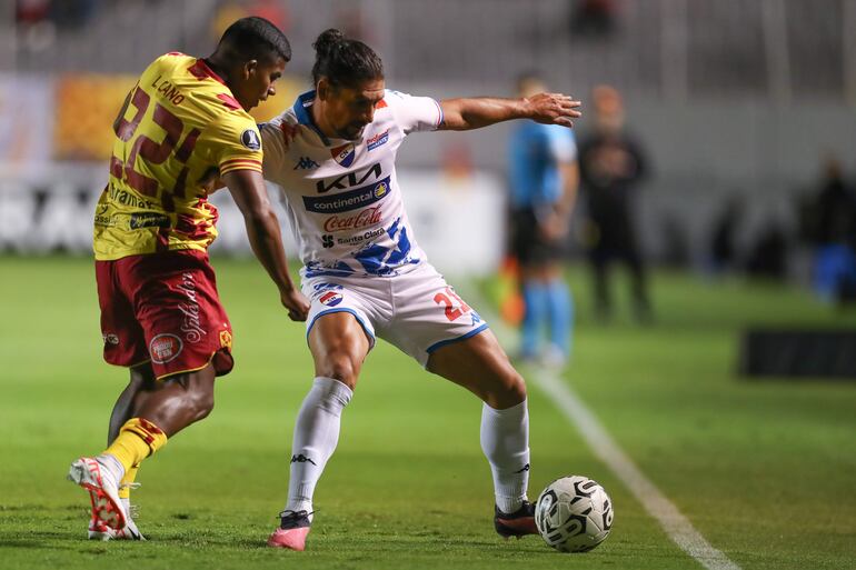 El paraguayo Blas Cáceres (d), futbolista de Nacional, domina el balón ante Luis Cano (i), jugador de Aucas, en un partido de la Fase 1 de la Copa Libertadores ene el estadio Gonzalo Pozo Ripalda, en Quito, Ecuador.