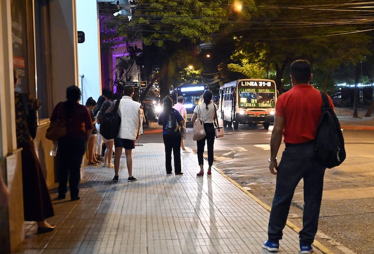 Pasajeros en parada de buses en el centro de Asunción.