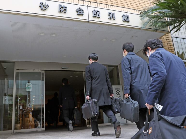 Agentes de la fiscalía de japonesa ingresan a la sede del Partido Democrático Liberal.