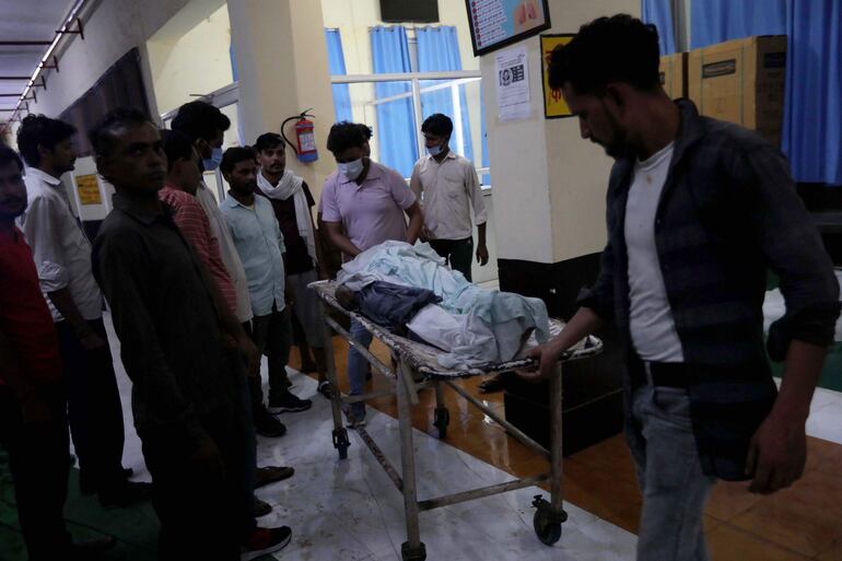 Familiares transportan el cuerpo de una víctima de estampida después de su identificación fuera de un hospital en Hathras, Uttar Pradesh, India.