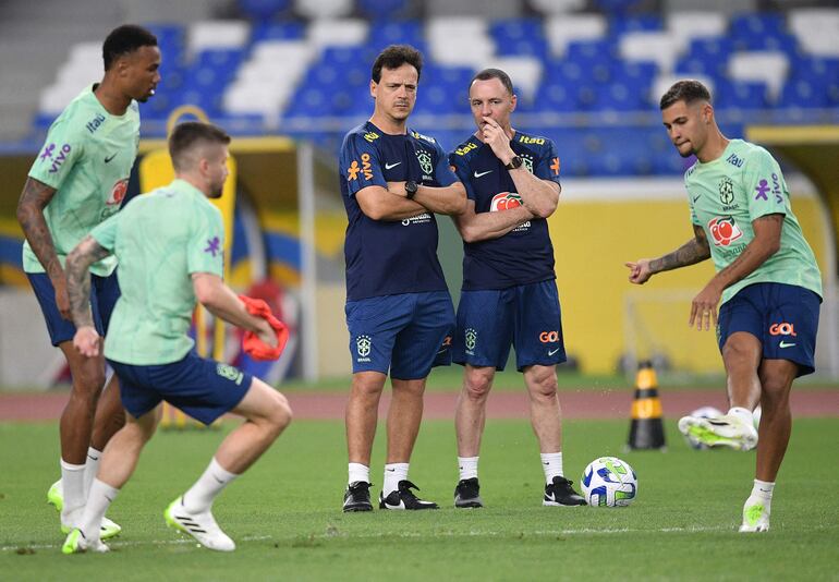 El entrenador Fernando Diniz (C) observa la práctica de los jugadores de la selección brasileña, que se prepara para recibir mañana a Bolivia.