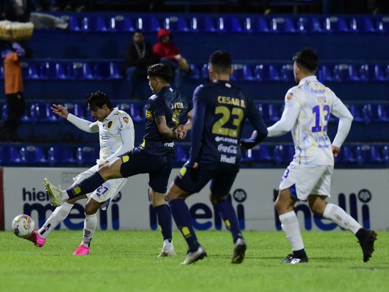 Jorge Benítez (i), jugador de Sportivo Luqueño, ejecuta un balón en el partido frente a Sportivo Trinidense por el torneo Clausura 2024 del fútbol paraguayo en el estadio Luis Alfonso Giagni, en Villa Elisa, Paraguay.