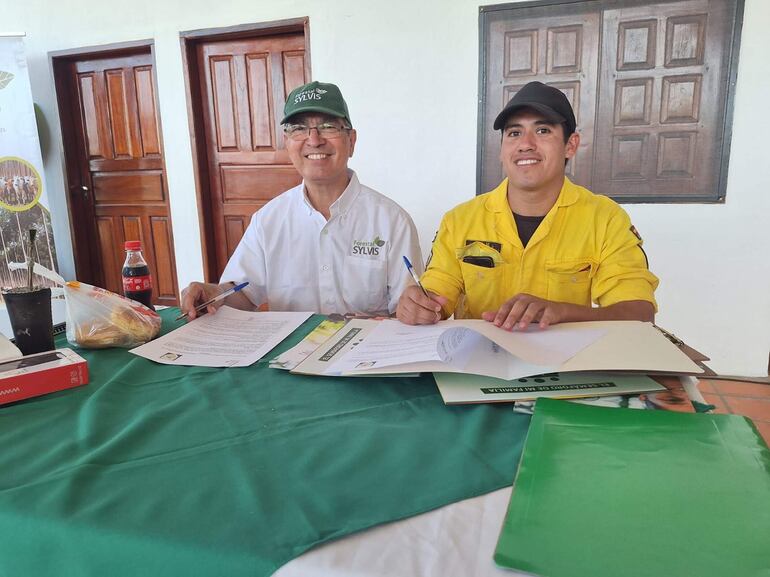 Raúl Gauto, de Forestal Sylvis, y Mauro Ortiz, comando de compañía de K141 de Caazapá, firman el convenio para combatir incendios forestales.