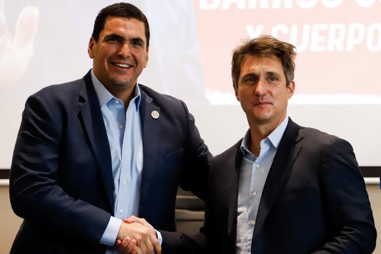 Robert Harrison (i), presidente de la Asociación Paraguaya de Fútbol, saluda a Guillermo Barros Schelotto (d) durante la presentación del argentino como entrenador de la selección paraguaya en la sede de la Asociación Paraguaya de Fútbol, en Luque, Paraguay.