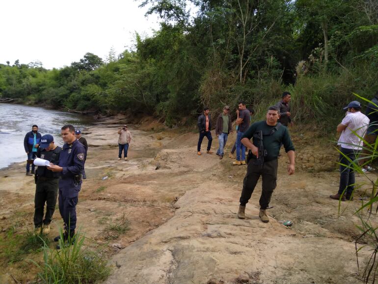 Efectivos policiales a orillas del río Jejuí donde hallaron el cuerpo sin vida de quien sería Enrique Noguera Paredes, quien estaba desaparecido.
