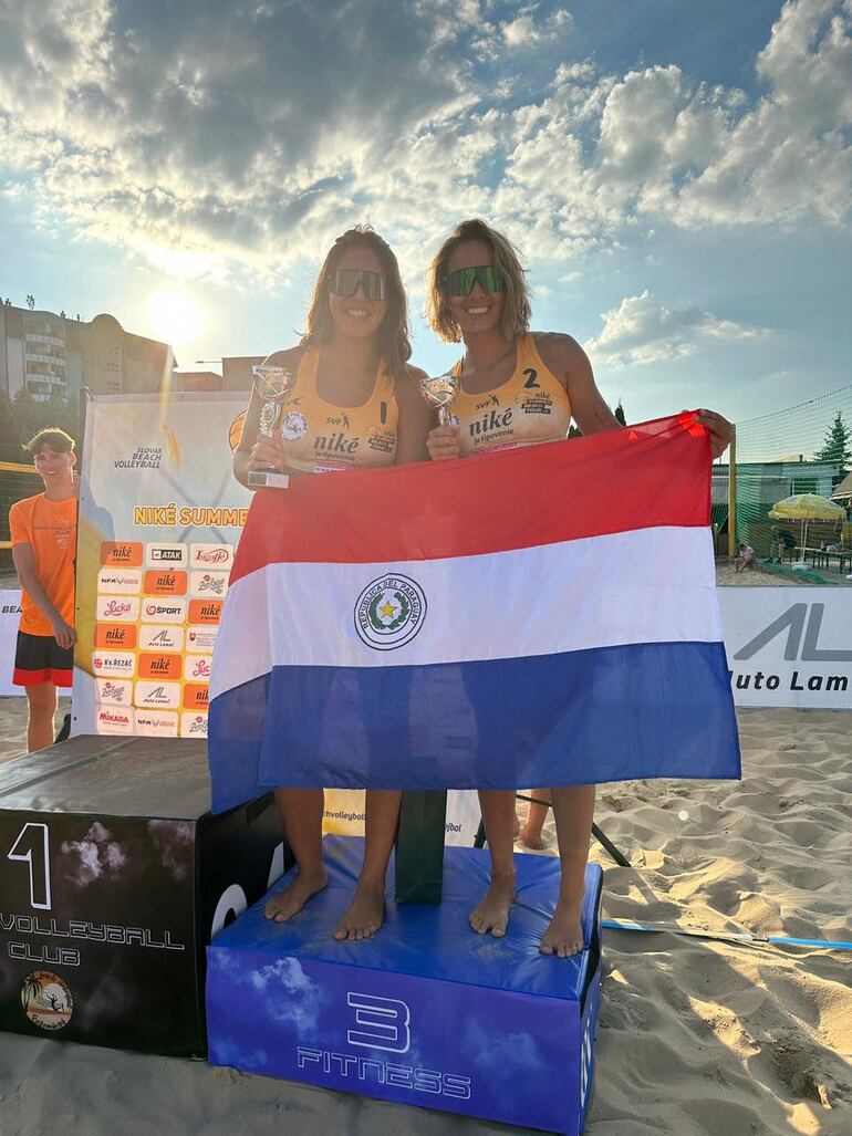 Giuli y Laura en el podio de Eslovaquia con la bandera paraguaya.