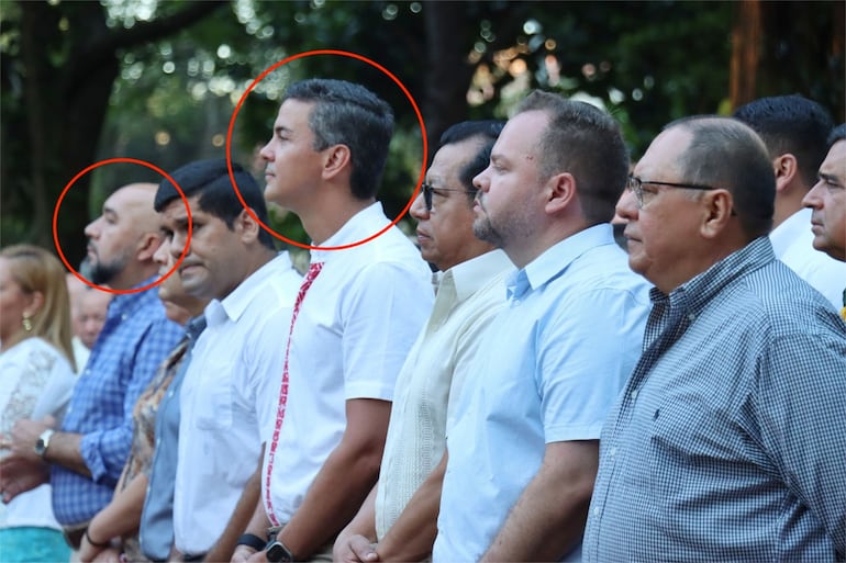 En círculo, el diputado cartista Orlando Arévalo y el presidente Santiago Peña en una misa en honor a San Blas en la parroquia San Blas, de Itá, instantes antes de que se revelara el escándalo que tiene en el centro de la tormenta al parlamentario, por sus chats con el asesinado "Lalo" Gomes.