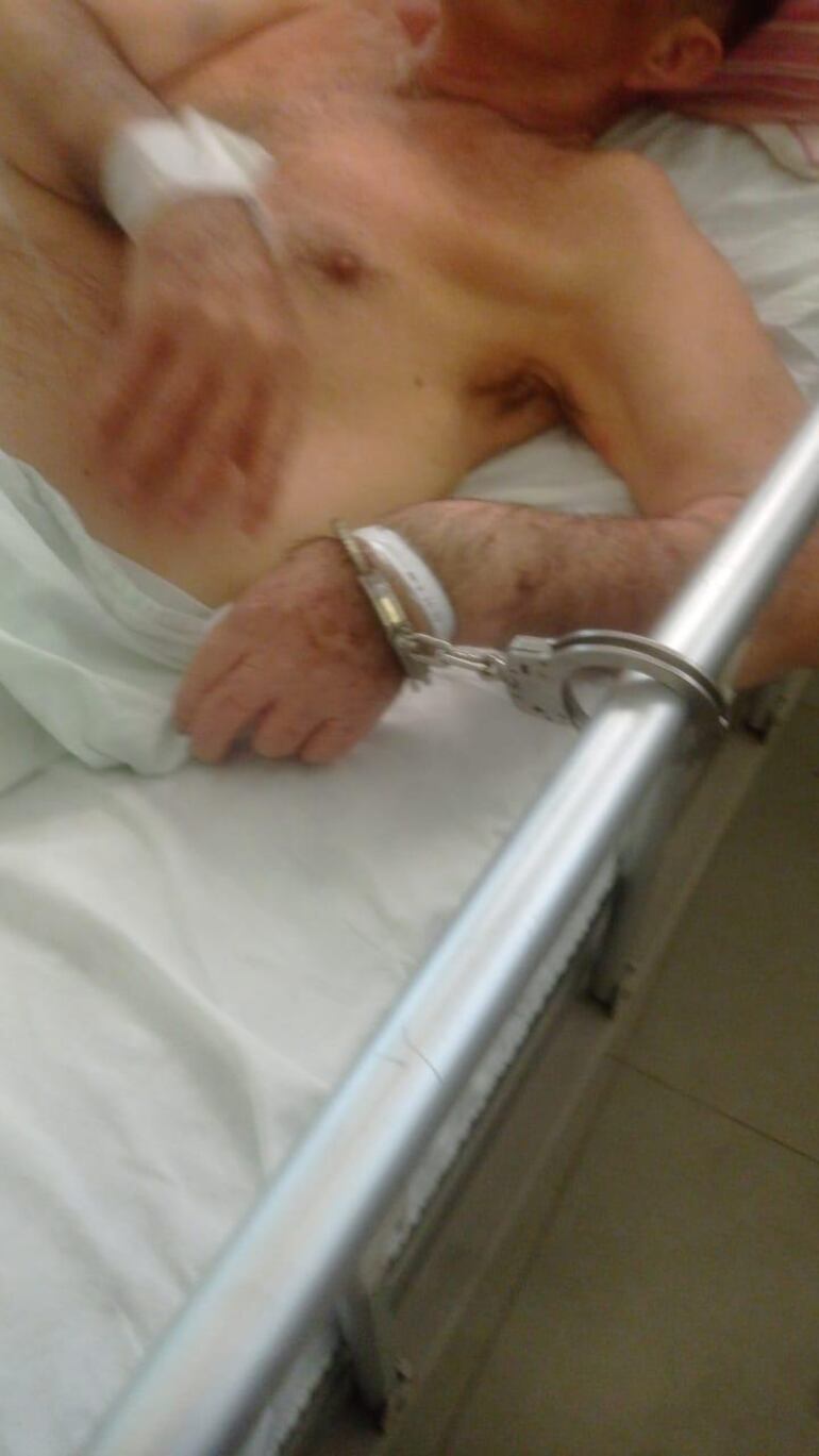 hombre esposado en la cama de un hospital