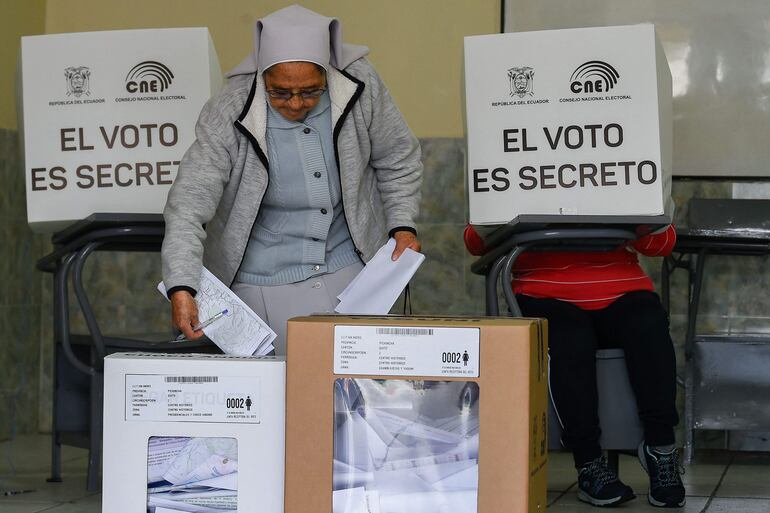 A nun votes at a polling station in Quito during the Ecuadorean presidential election and referendum on mining and petroleum, on August 20, 2023. Ecuador holds a presidential election after a campaign marked by the murder of a top candidate and vows to tackle the lawlessness that has engulfed the once-peaceful nation. Alongside the presidential vote, two key referendums are taking place in one of the world's most biodiverse countries. One will ask voters to choose whether to continue oil drilling in the Amazon, and another focuses on whether to forbid mining activities in the Choco Andino forest. (Photo by Camila BUENDIA / AFP)