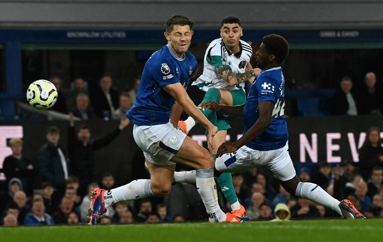 Everton's English defender #06 James Tarkowski defends a shot from Newcastle United's Paraguayan midfielder #24 Miguel Almiron during the English Premier League football match between Everton and Newcastle United at Goodison Park in Liverpool, north west England on October 5, 2024. (Photo by Paul ELLIS / AFP) / RESTRICTED TO EDITORIAL USE. No use with unauthorized audio, video, data, fixture lists, club/league logos or 'live' services. Online in-match use limited to 120 images. An additional 40 images may be used in extra time. No video emulation. Social media in-match use limited to 120 images. An additional 40 images may be used in extra time. No use in betting publications, games or single club/league/player publications. / 