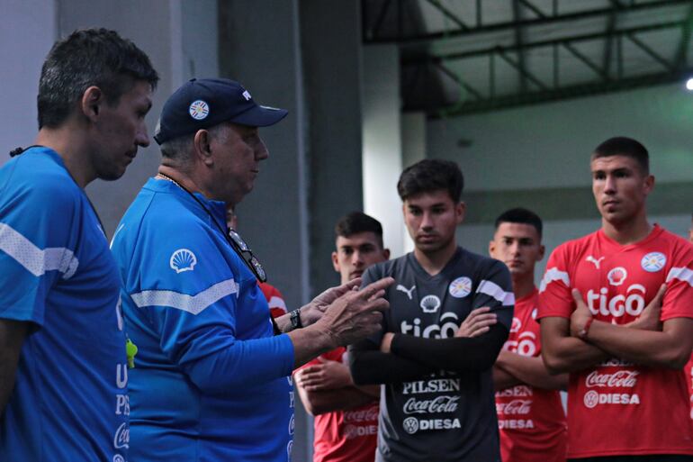 Carlos Jara Saguier (quepis), entrenador de la selección paraguaya, conversa con los jugadores en el entrenamiento en el CARDE de Ypané.