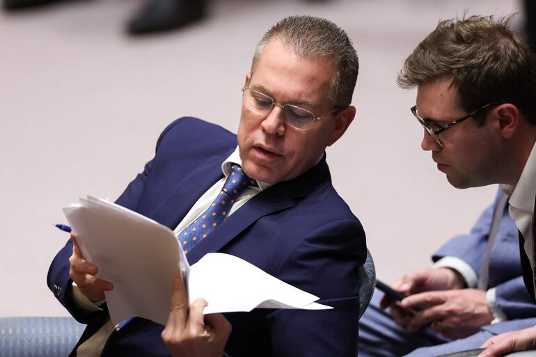 El embajador de Israel ante las Naciones Unidas, Gilad Erdan (i) conversa con un asistente durante la reunión de urgencia del Consejo de Seguridad. 