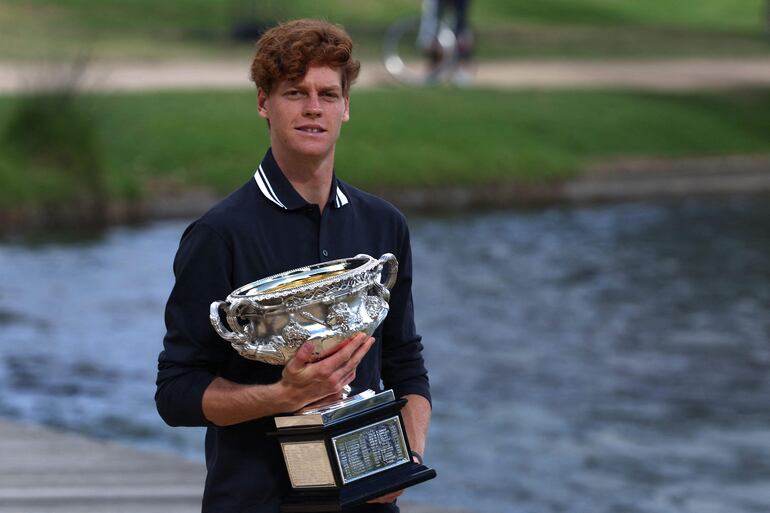 El italiano Jannik Sinner posa con el trofeo de la Norman Brookes Challenge Cup tras su victoria contra el alemán Alexander Zverev en la final masculina individual del torneo de tenis del Abierto de Australia en Melbourne.