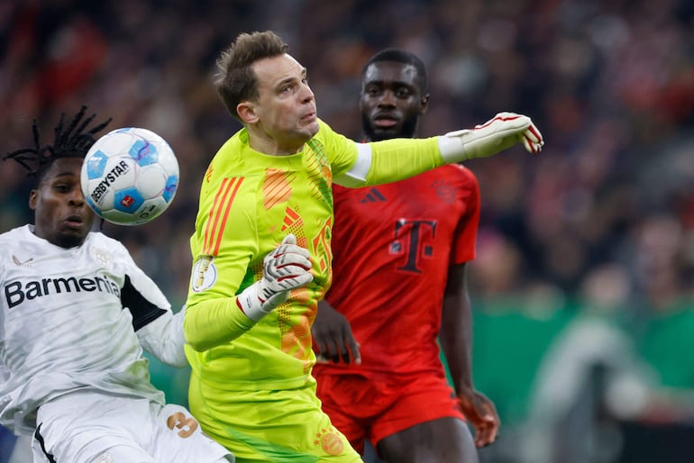 Bayern Munich's German goalkeeper #01 Manuel Neuer fouls Bayer Leverkusen's Dutch defender #30 Jeremie Frimpong during the German Cup (DFB Pokal) round of 16 football match FC Bayern Munich v Bayer Leverkusen in Munich, southern Germany, on December 3, 2024. (Photo by Michaela STACHE / AFP) / DFB REGULATIONS PROHIBIT ANY USE OF PHOTOGRAPHS AS IMAGE SEQUENCES AND QUASI-VIDEO.