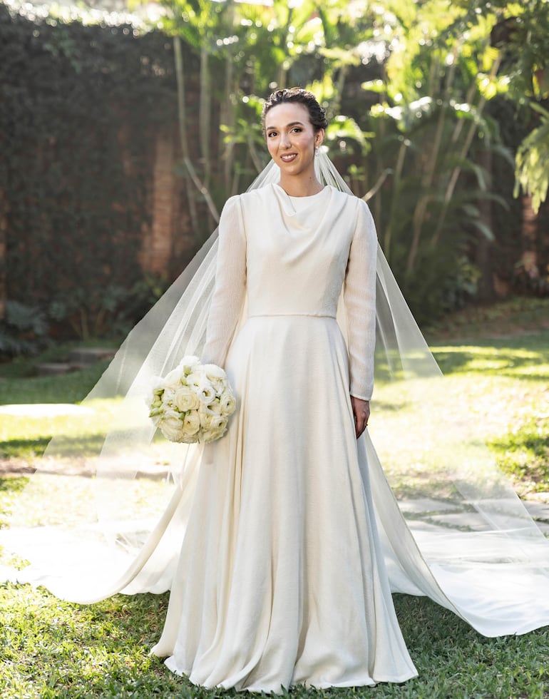 La novia lució un vestido totalmente blanco y muy delicado, diseñado y confeccionado por Loli Ferrés, quien también se encargó del velo y ramo de Inés.