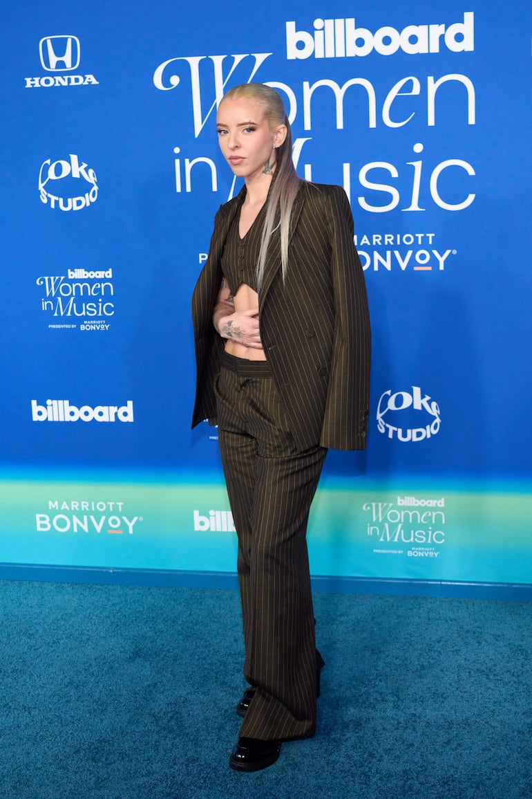 La rapera puertorriqueña Young Miko eligió un traje oscuro con rayas para pasar por la alfombra de los Billboard Women in Music Awards. (EFE/EPA/ALLISON DINNER)
