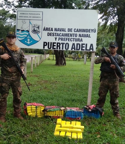 Agentes de la Prefectura Naval posan junto a la carga de marihuana incautada antes de ser llevada al Brasil.