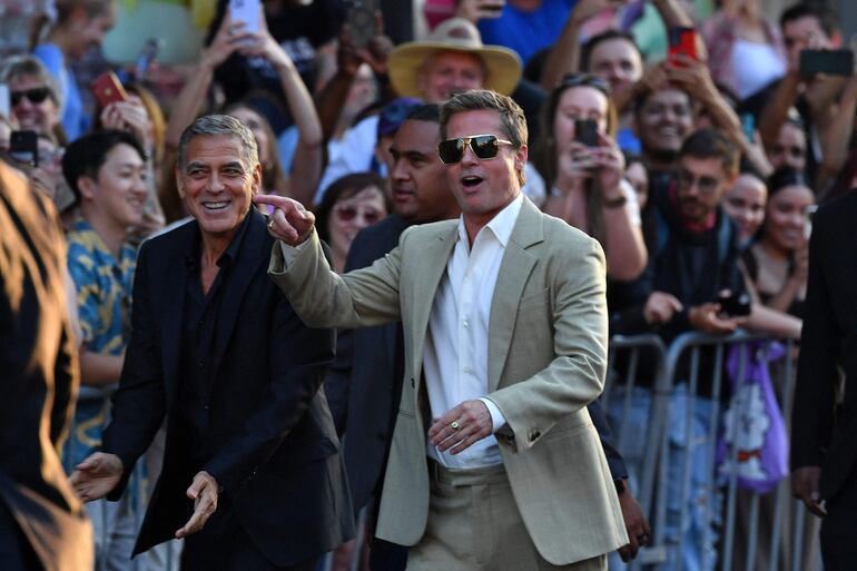 Los actores estadounidenses George Clooney y Brad Pitt llegando sonrientes al estreno de "Wolfs" de Apple en el Teatro Chino TCL de Hollywood, California. (Valerie Macon / AFP)