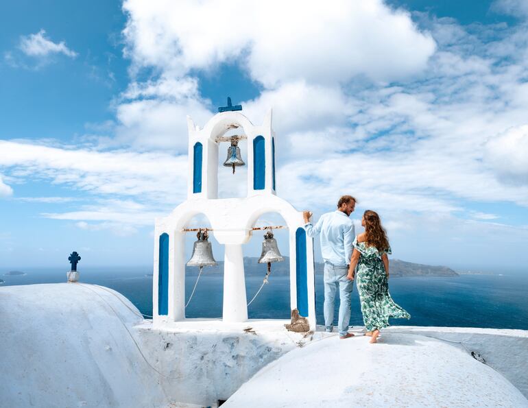 Pareja de viajeros de luna de miel en Oia, en la isla de Santorini, Grecia.