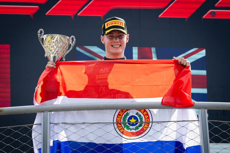 Joshua Duerksen festeja con la copa en mano, una amplia sonrisa y la infaltable bandera tricolor.