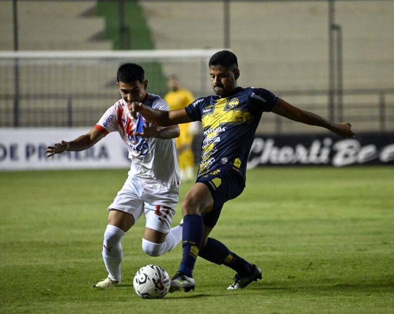 César Benítez rechaza el balón ante la presencia de Gabriel Aguayo